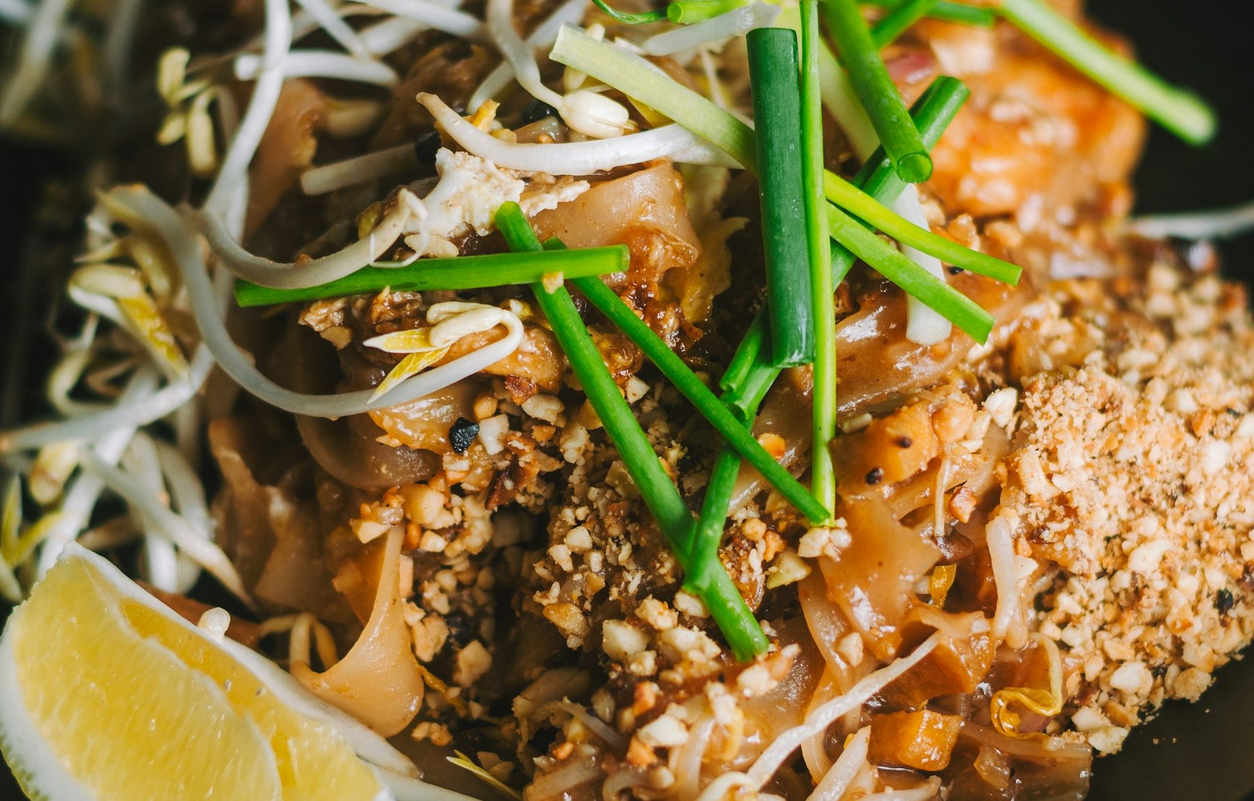 A plate of Pad Thai noodles with prawns, egg and crushed peanuts